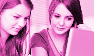 Two young women looking at a laptop screen