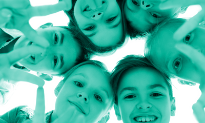 Young people in a circle looking down at the camera