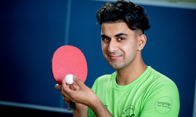 Young boy holding table tennis paddle and ball
