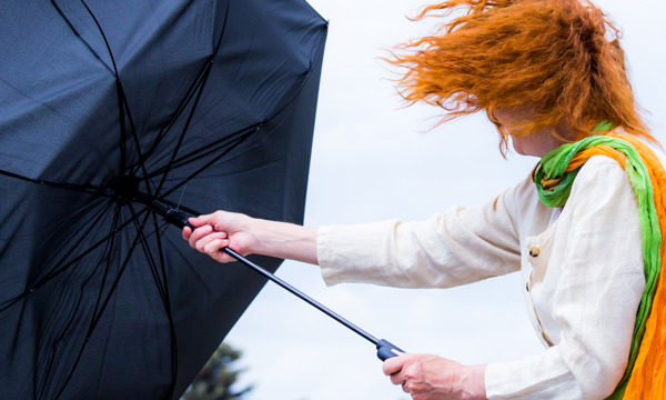 Umbrella blowing inside out in wind and rain