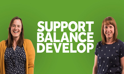 Two women outside 'Support, Balance, Develop' logo