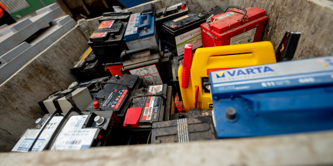 Car batteries in a container at a recycling centre.