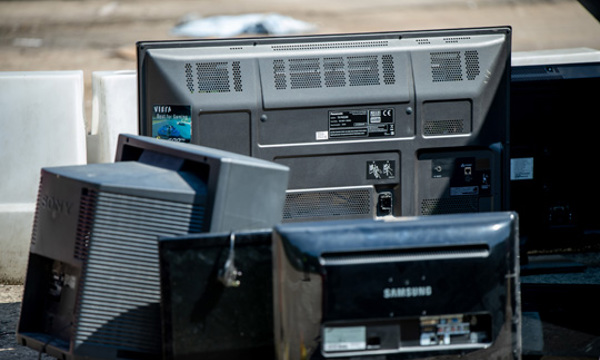 Old televisions and monitors at a recycling centre.