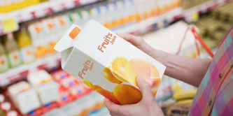 A lady holding a fruit juice carton.