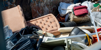 Items of furniture and other bulky waste in a container at a recycling centre.