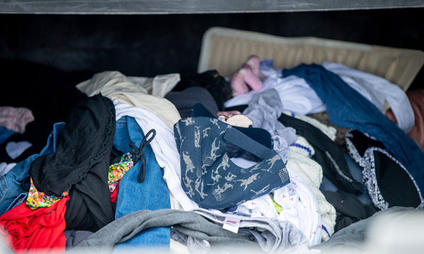 Clothes and other textiles in a textile container in a recycling centre.