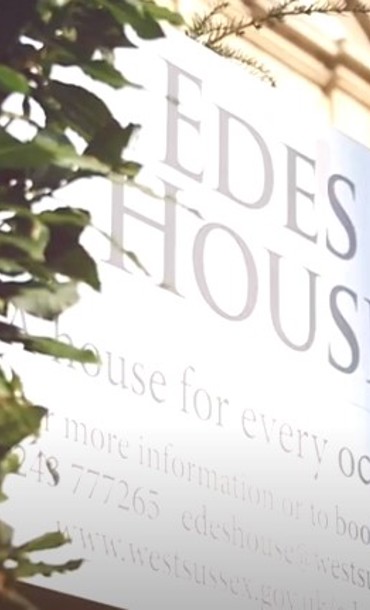 Edes House sign and part of the building shaded by a tree