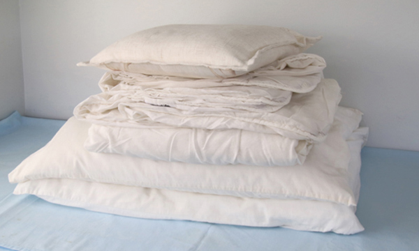 A pile of cushions, duvets and pillows.