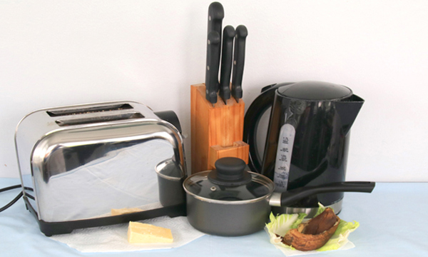 Items of kitchen waste - food, old saucepan, kettle, toaster.