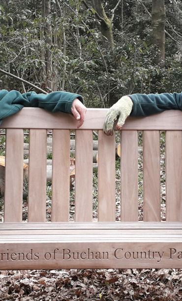 two volunteers sat on a wooden bench