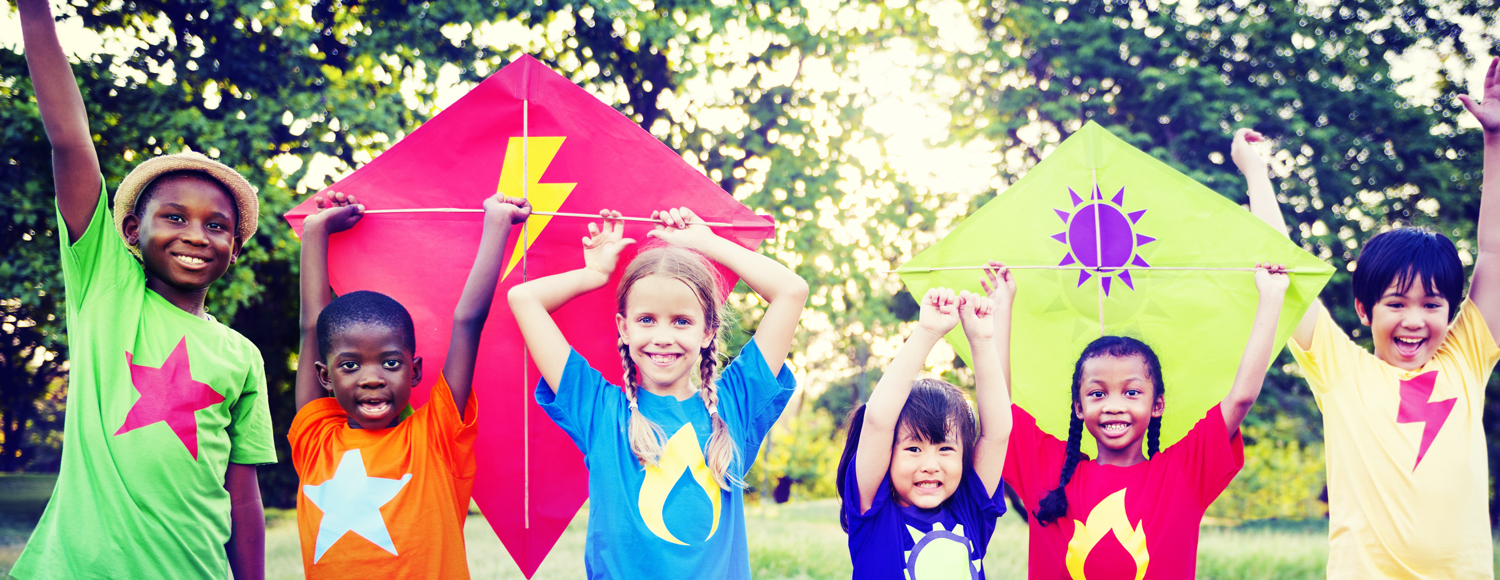 Image of children in bright colours holding kites