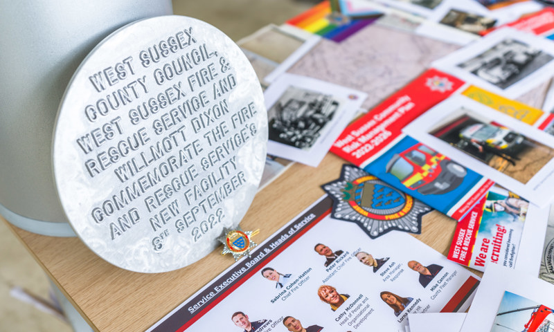 Photo of some contents within the time capsule - including a plaque and structure chart of West Sussex Fire & Rescue Service..