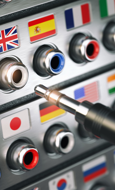 Headphone jacks in various languages with a cable poised to plug into English.