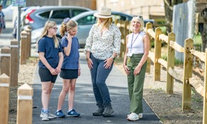 Perusing the footway improvements and new crossing points near Barns Green Primary School: from left, two of the school's pupils with County Council Cabinet Member for Highways and Transport Joy Dennis and Headteacher Tracey Newbold