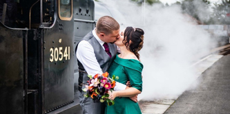 Bride and groom next to a train