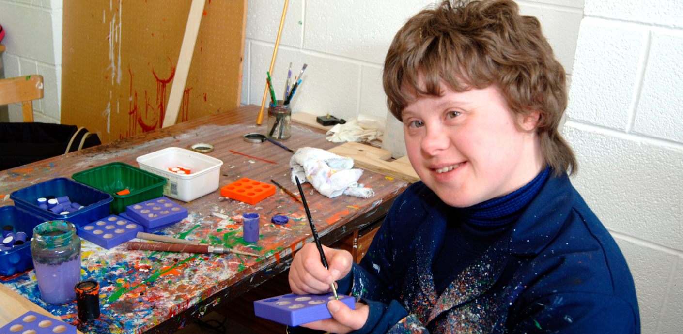 nojs Boy with special needs smiling and painting.