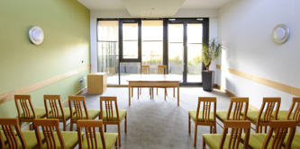 Chairs laid out in a bright, modern room facing glass windows and doors