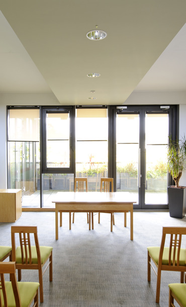 Chairs laid out in a bright, modern room facing glass windows and doors