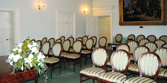 Elegant ceremony room with chairs laid out and large painting in the background
