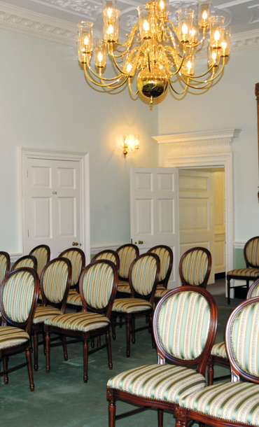 Elegant ceremony room with chairs laid out and large painting in the background