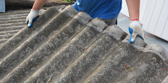Man carrying asbestos sheet with gloves