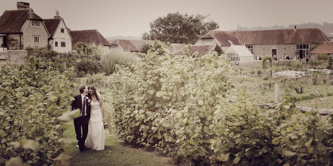 A bride and groom walking at Grittenham Barn.