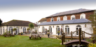 Angmering Manor with bridge over pond.