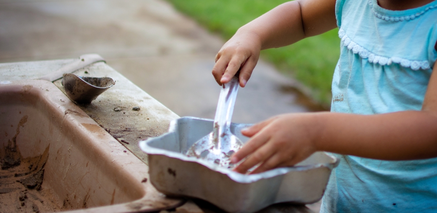 nojs Child playing in a mud kitchen