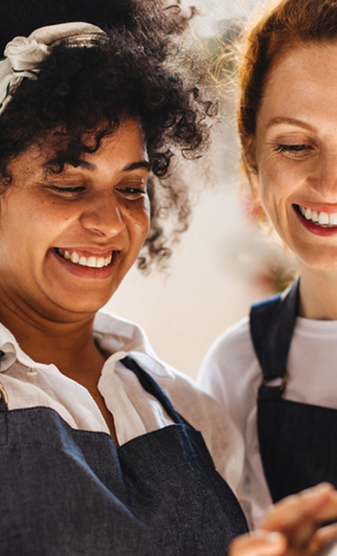 Two women wearing aprons