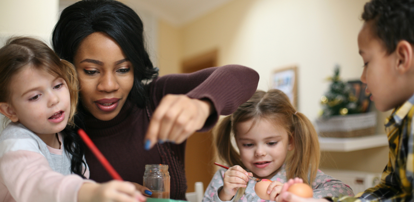 nojs Adult with 3 children playing round a table