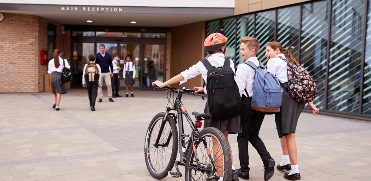 nojs Three students walking, one with a bike