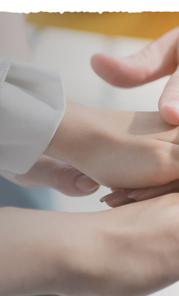Six hands overlapping one another in unity.